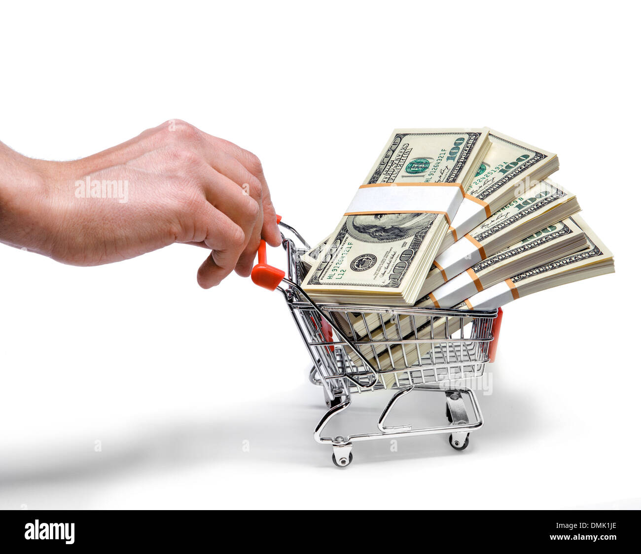 Businessman's hand pushing shopping cart full of Stacks of dollar bills Banque D'Images