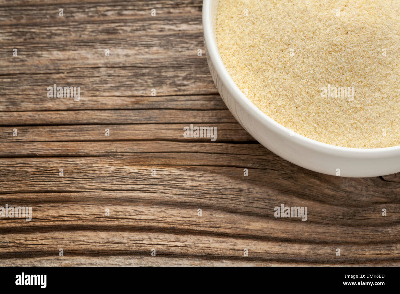 La semoule de farine de blé - un bol en céramique blanche sur un bois à grain fin Banque D'Images