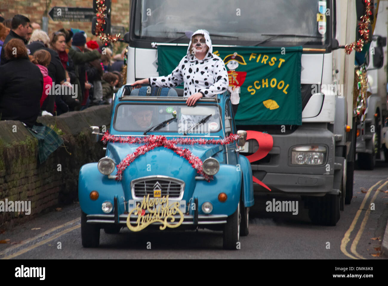 Wimborne, Dorset, Royaume-Uni. 14 décembre 2013. Les foules se détournent pour assister au 25ème défilé de Noël de Wimborne Save the Children. Citroën 2 CV 6 2CV 2CV6 voiture spéciale décorée de tinsel et Joyeux Noël avec passager vêtu de costume de chien dalmate à pois. Crédit : Carolyn Jenkins/Alay Live News Banque D'Images