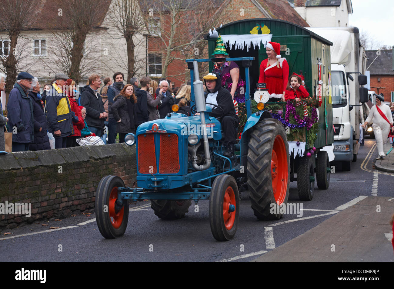 Wimborne, Dorset Royaume-Uni Samedi 14 décembre 2013. Les foules se détournent pour assister au 25ème défilé de Noël de Wimborne Save the Children. Tracteur décoré avec conducteur habillé comme pingouin. Banque D'Images