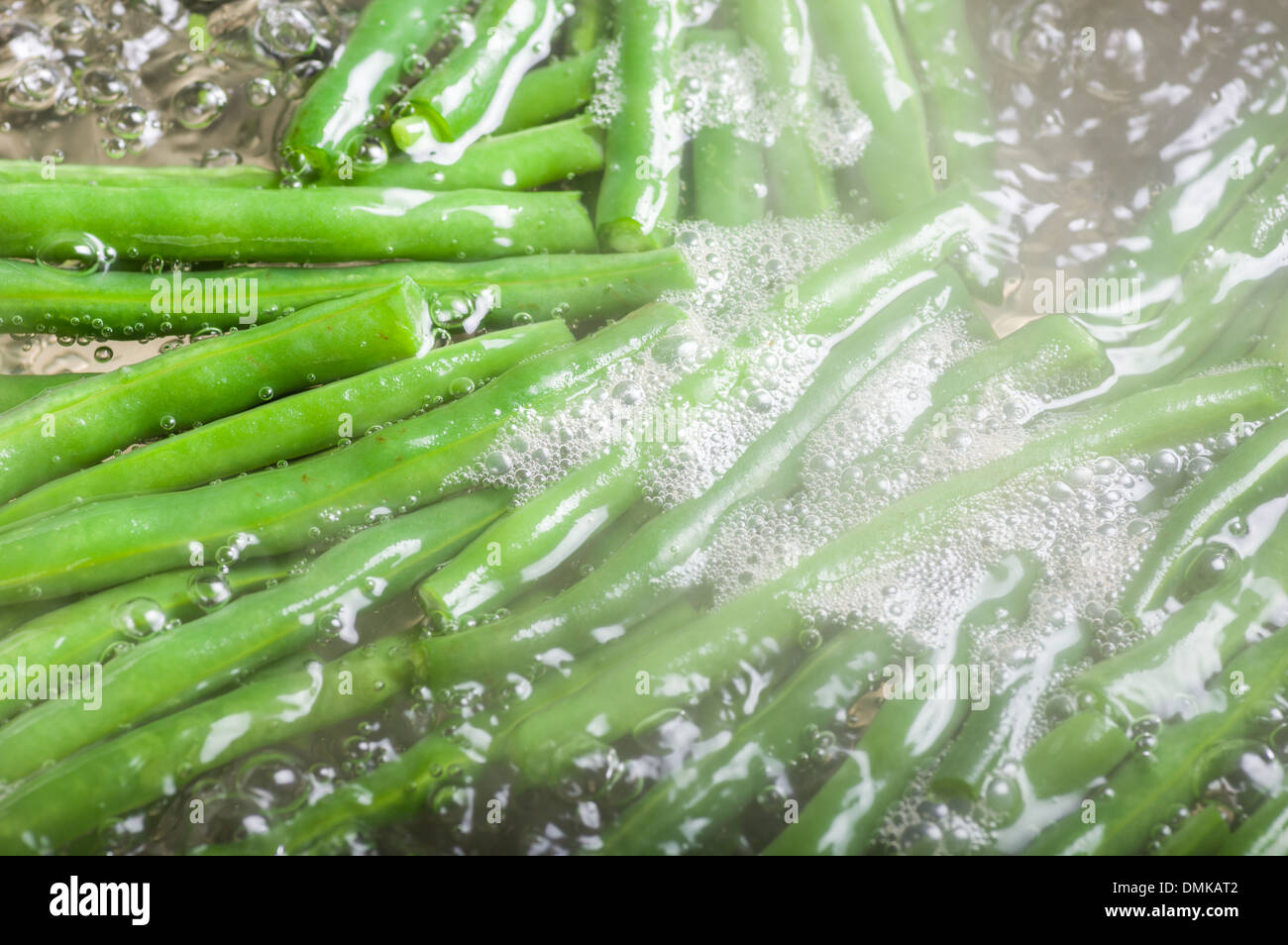 Haricots verts frais dans l'eau bouillante sur la cuisinière Banque D'Images