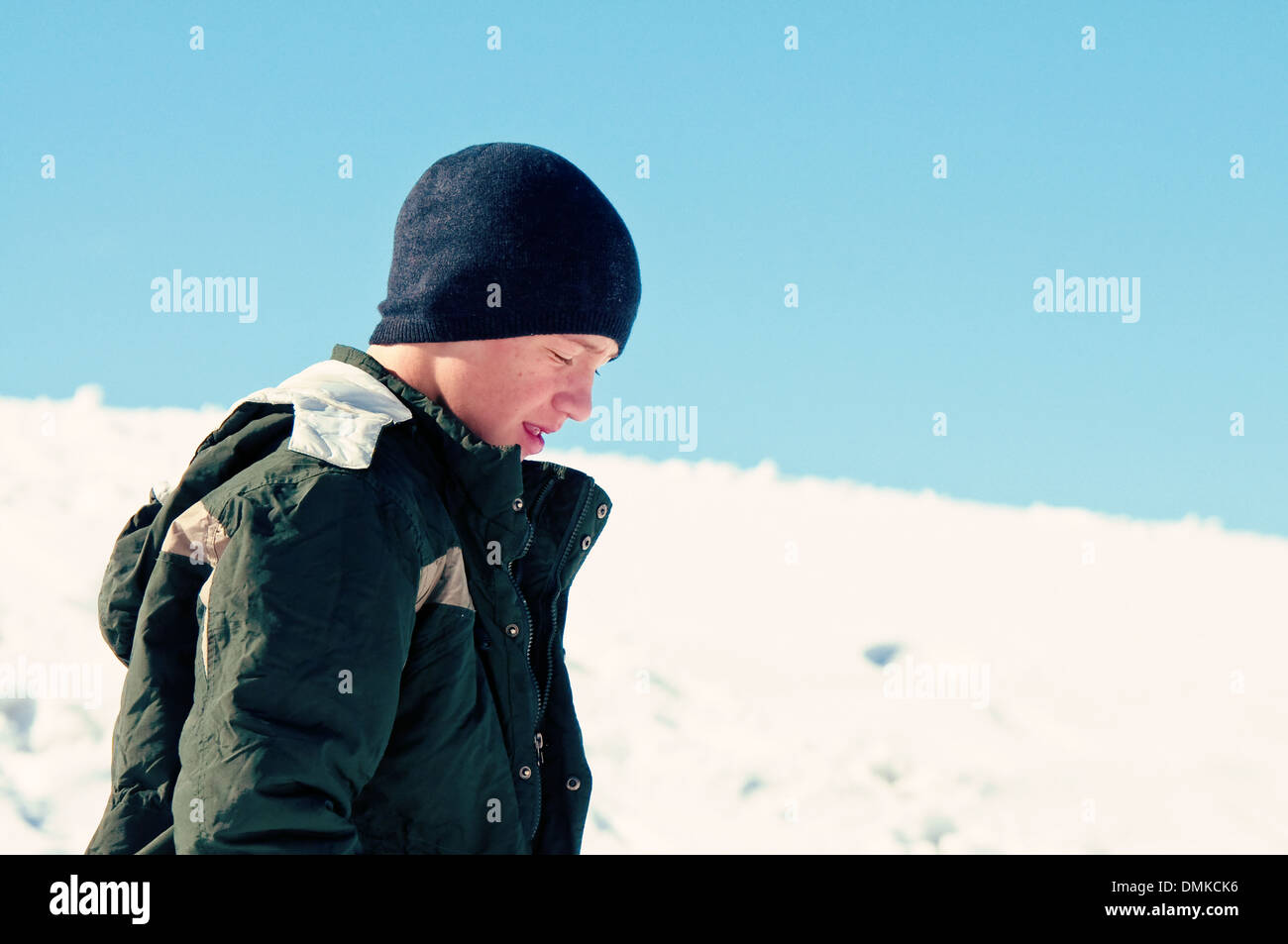 Teen boy walking in snow à la triste Banque D'Images
