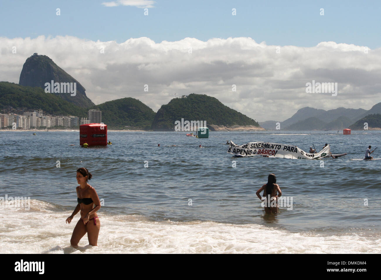 La plage de Copacabana, Rio de Janeiro, Brésil, 14 décembre 2013. Les activistes de la 'Jungle Battiari Saneamento do' (l'été de l'assainissement) ouvrir une campagne bannière dans la mer au cours de la 'Roi et Reine de la mer' tournoi de natation en eau libre. Ils demandent un plan d'assainissement non gouvernementales qui englobe toute la ville. Crédit : Maria Adelaide Silva/Alamy Live News Banque D'Images