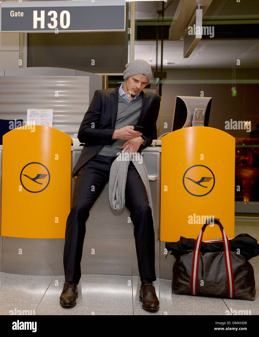 L'aéroport de Munich, Allemagne. 14 Décembre, 2013. Joueur Bayern Munich Daniel van Buyten s'assied avant le départ de l'équipe d'Agadir (Maroc) à l'aéroport de Munich, Allemagne, le 14 décembre 2013. Bayern Munich fera face à Guangzhou Evergrande FC dans la demi-finale match de foot de la Coupe du Monde des Clubs de la FIFA 2013 le 17 décembre 2013. Photo : David Ebener/dpa/Alamy Live News Banque D'Images
