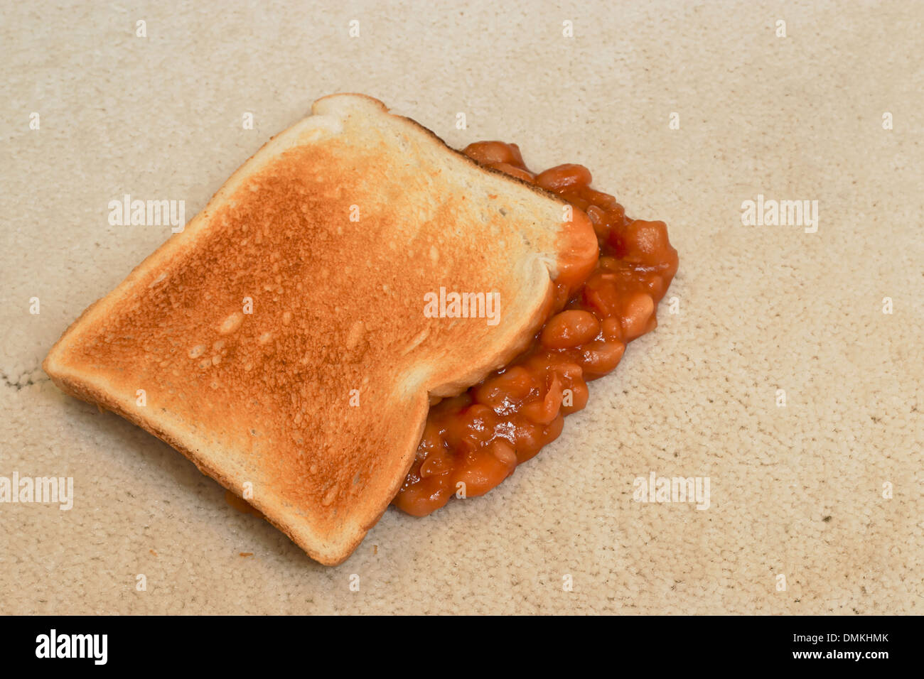 Les haricots sur toast une chute accidentelle et la création d'une tache sur tapis de sol velours beige Banque D'Images