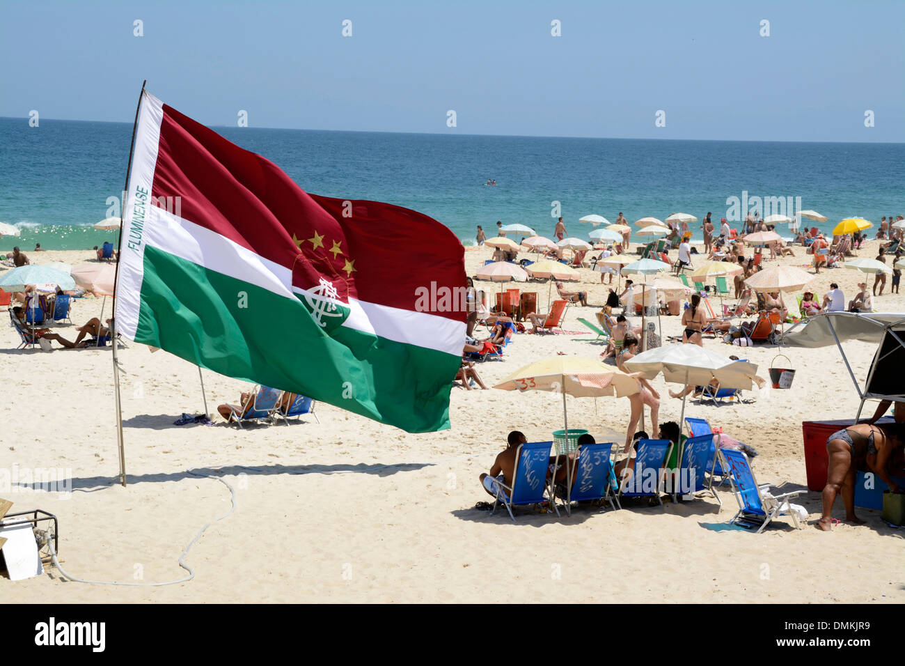 Un petit groupe de supporters de football avec leurs propres drapeaux de soutien de football tels que le drapeau Fluminense FC sur la plage d'Ipanema à Rio de Janeiro, Brésil Banque D'Images