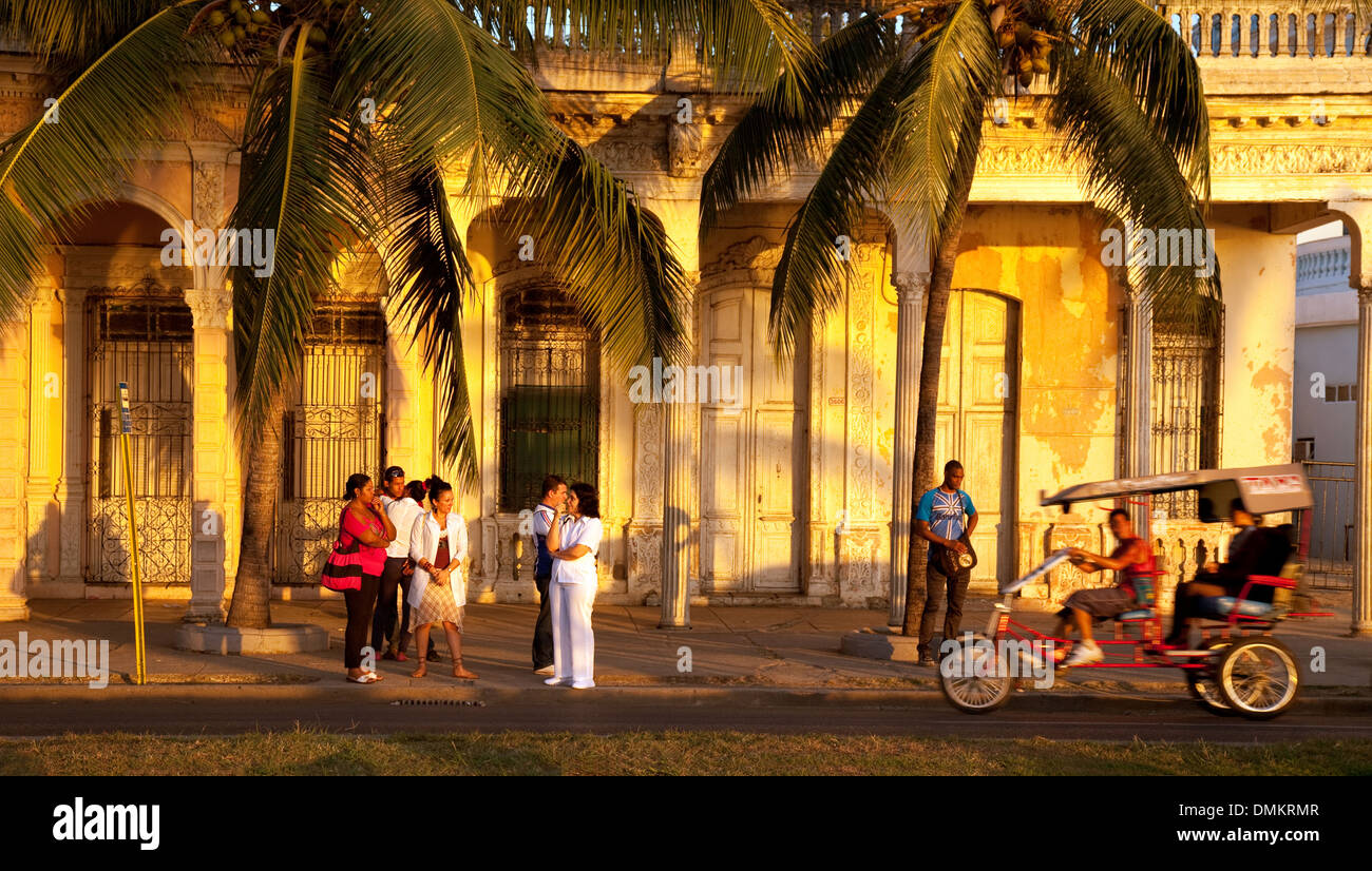 La population locale et de vélo taxi en soirée, scène de rue, Cienfuegos ( site du patrimoine mondial de l'Unesco ), de Cuba, des Caraïbes, d'Amérique latine Banque D'Images