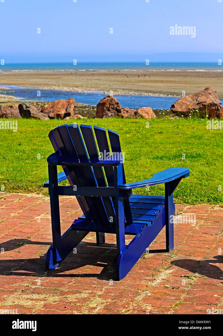 Adirondack bleu une chaise de plage donnant sur la plage. Banque D'Images