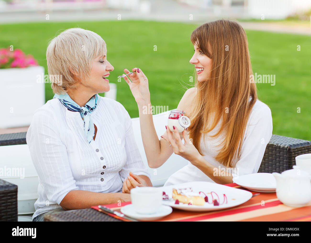 Les cadres supérieurs et les jeunes fille séduisante mère manger un gâteau, de boire du café au coffee shop, smiling Banque D'Images