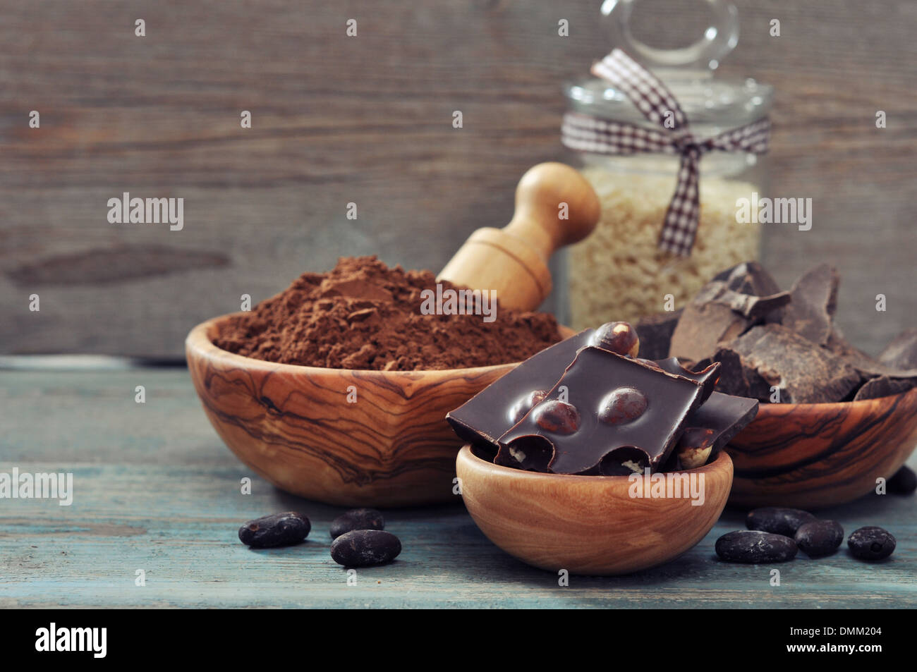 Morceaux de chocolat avec des fèves de cacao et poudre de cacao sur fond de bois Banque D'Images