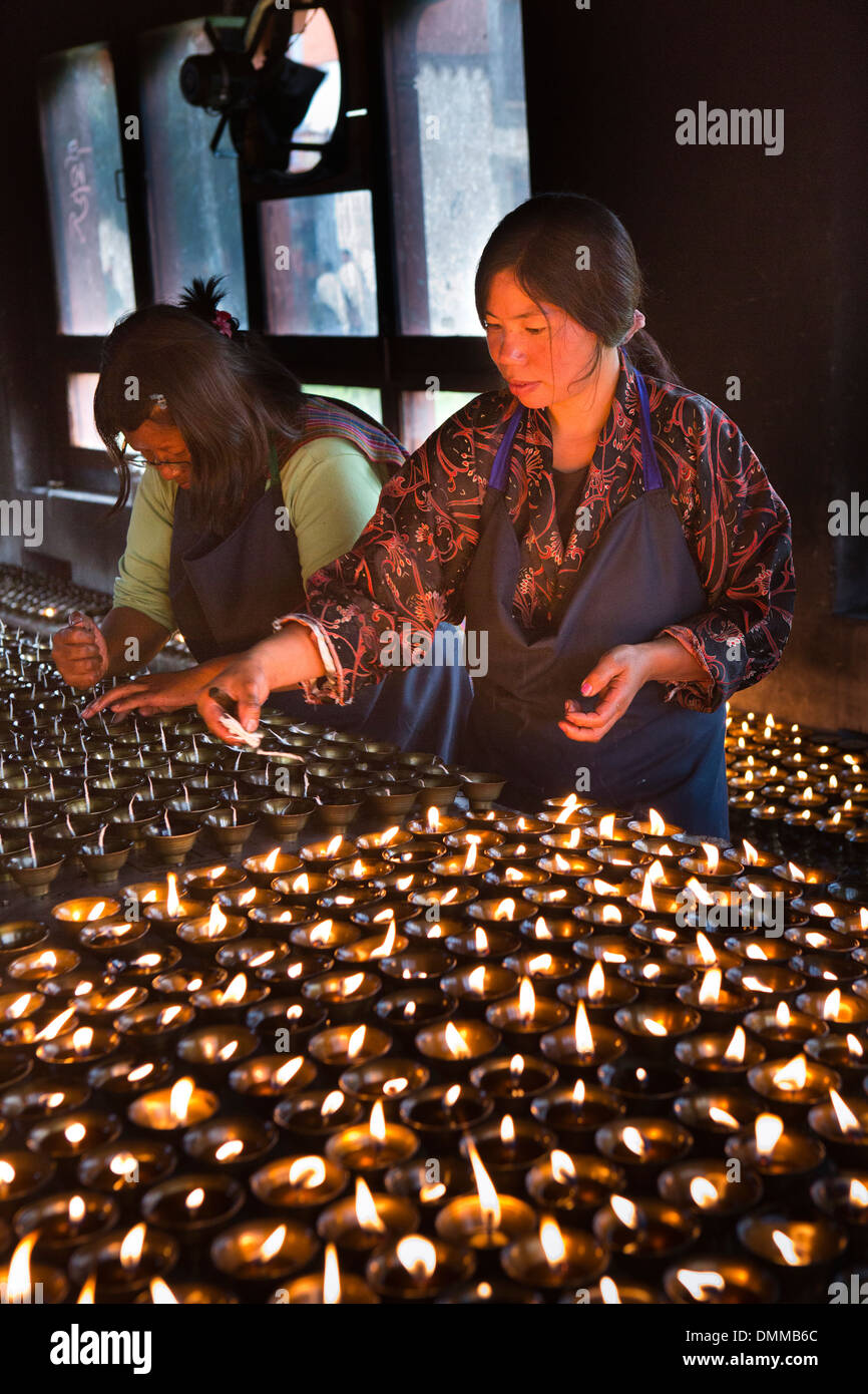 Le Bhoutan, la vallée de Bumthang, Jambey Lhakang, monastère, éclairage femme lampes à beurre Banque D'Images