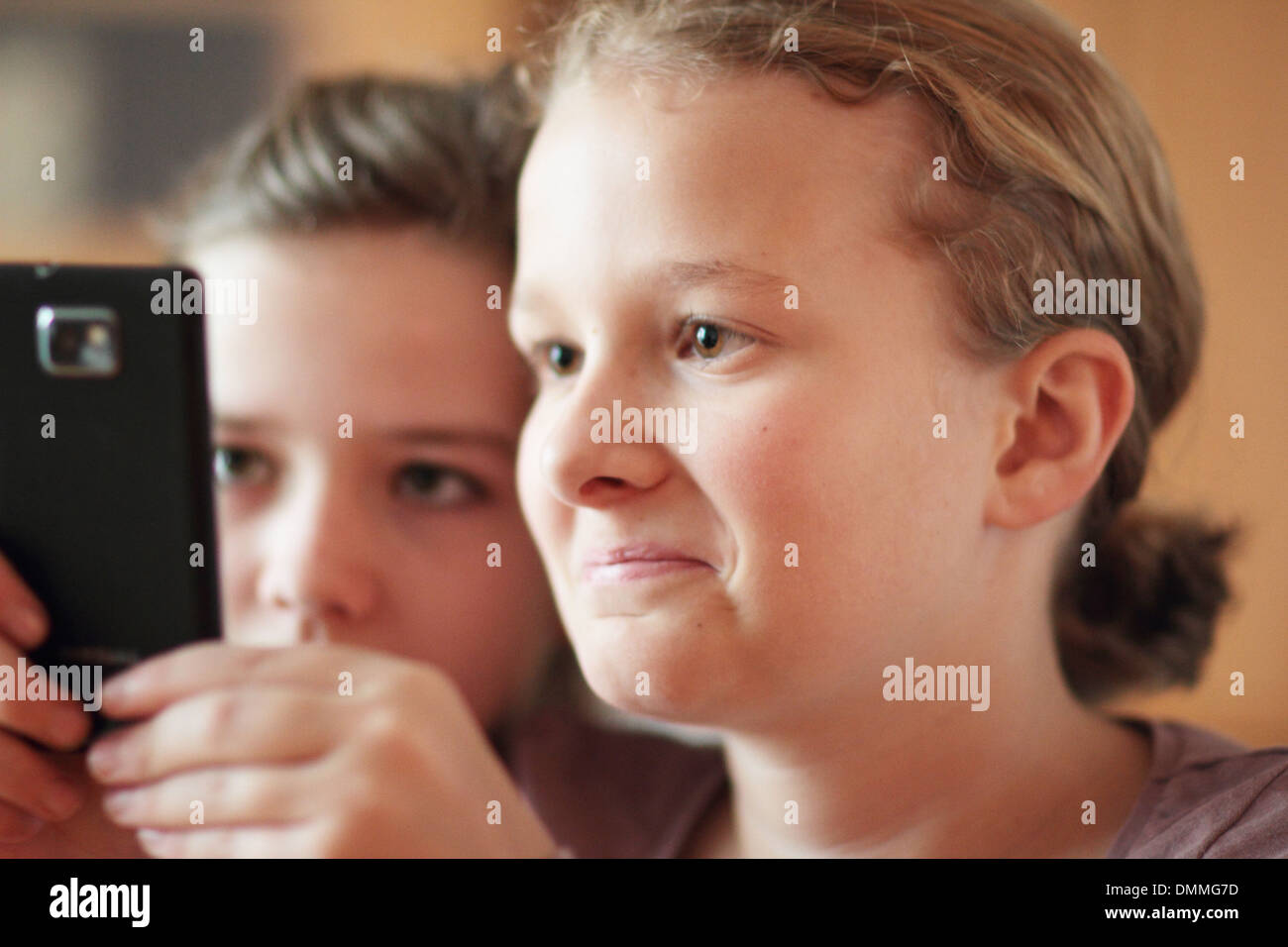 Les filles à la recherche d'un i phone dans une chambre ensemble Banque D'Images