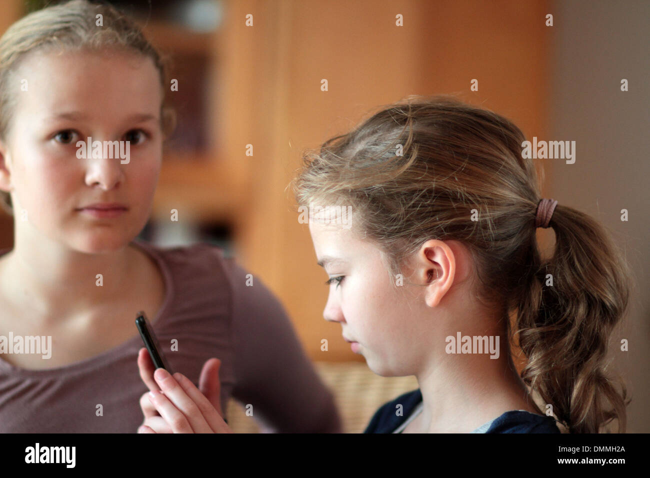 Les filles à la recherche d'un i phone dans une chambre ensemble Banque D'Images