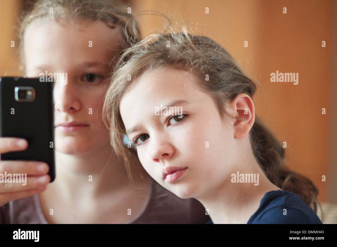 Les filles à la recherche d'un i phone dans une chambre ensemble Banque D'Images