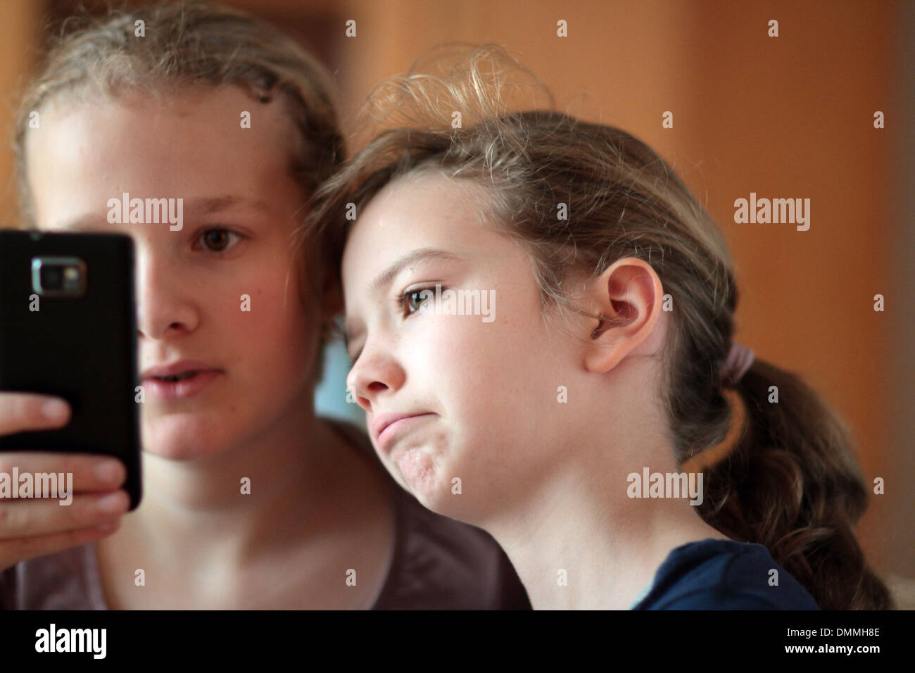 Les filles à la recherche d'un i phone dans une chambre ensemble Banque D'Images