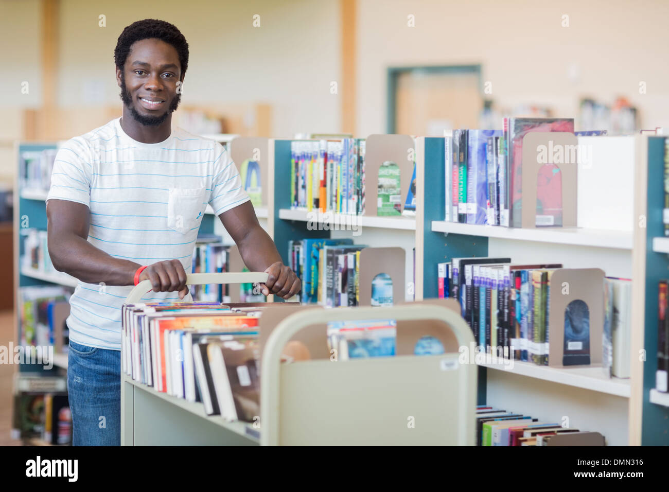 Bibliothécaire avec chariot de livres en librairie Banque D'Images