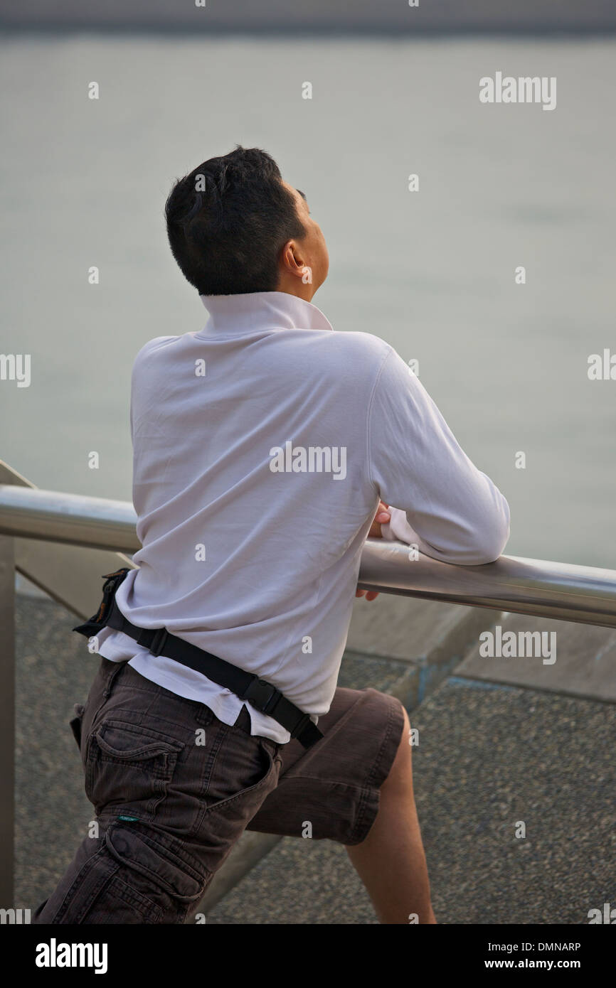 Jogger s'étend sur la promenade de Kowloon, Hong Kong. Banque D'Images