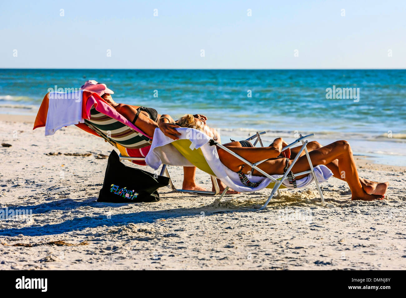 Deux personnes bénéficiant d'un bain de soleil sur une plage de Floride en décembre Banque D'Images