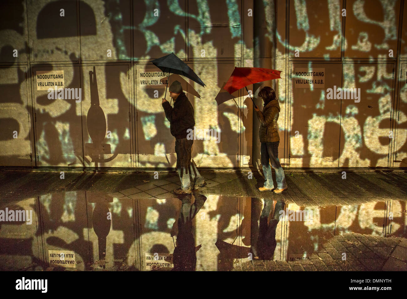 Pays-bas, Eindhoven, Light festival appelé GLOW 2013. Couple avec Senz storm parapluie à la performance. Randonnée pédestre Banque D'Images