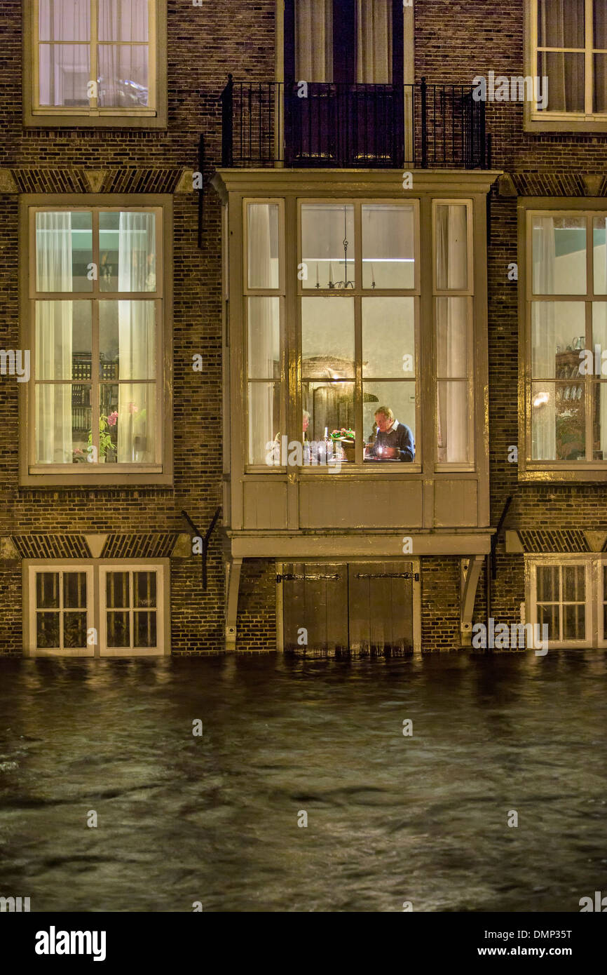 Dordrecht, Pays-Bas, le centre-ville historique dans l'inondation. Senior couple dîne au premier étage, tandis que le sous-sol est sous l'eau Banque D'Images