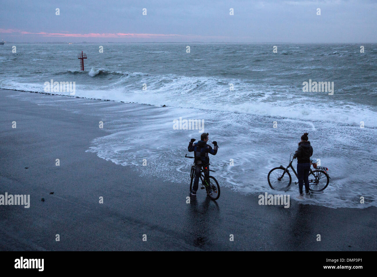 Pays-bas, Vlissingen, couple sur les bicyclettes se mouiller les pieds pendant les Banque D'Images