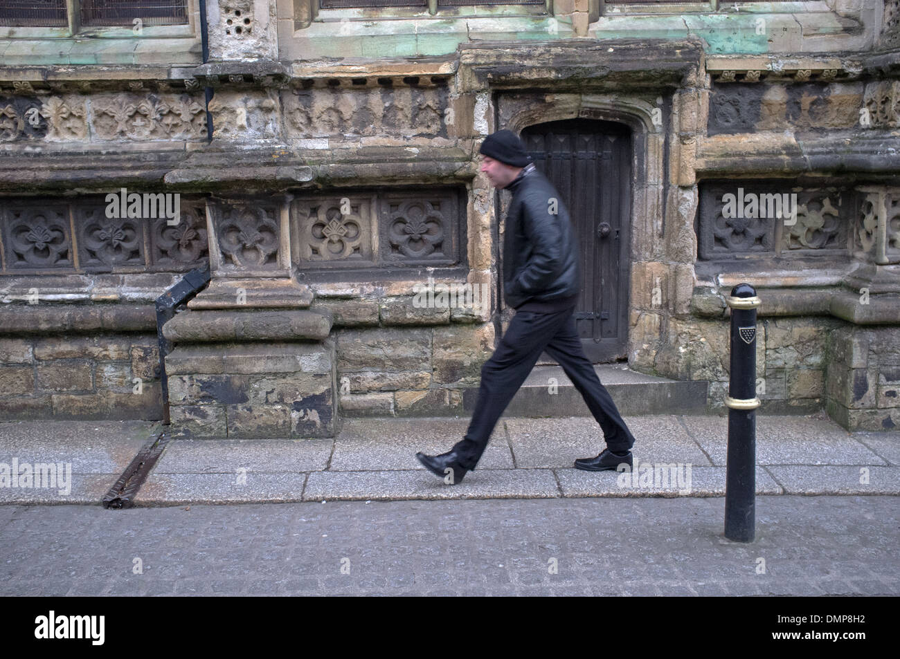 Un jour froid et venteux à Truro, Cornwall.Un homme passe devant la cathédrale de Truro Banque D'Images