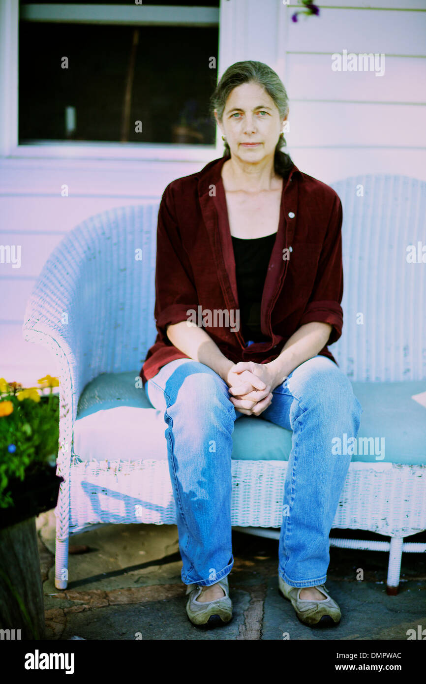 Fatigué mais bon espoir femme est assise sur son porche, attente de l'été, ses passions pour changer. Comme la lune se lève, elle se cale... Banque D'Images