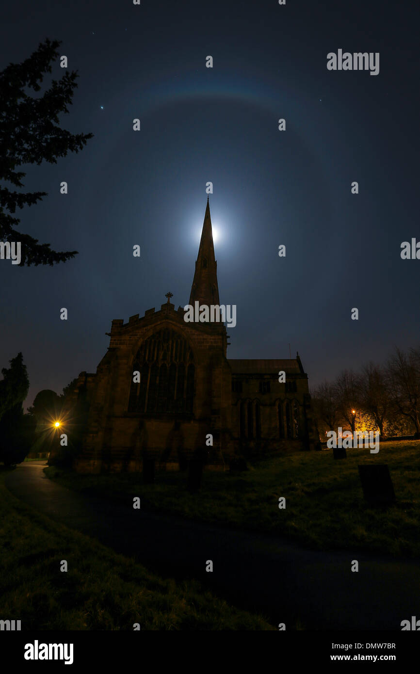 Ashbourne, Derbyshire, Royaume-Uni. 17 décembre 2013. Dans les premières heures de ce matin (mardi) une véritable celestial halo autour de la lune est suspendu au-dessus de l'église St Oswald à Ashbourne, dans le Derbyshire. Peut-être avec ce qui ressemble à une gigantesque boule de fête, des halos sont un signe de dérive cirrus minces haute 20 000 pieds ou plus au-dessus de nos têtes. Il y a un vieux dicton : météo, en anneau autour de la lune signifie la pluie plus tôt'. Il y a vérité dans ce dicton, car des nuages cirrus viennent souvent avant une tempête. Credit : Joanne Roberts/Alamy Live News Banque D'Images