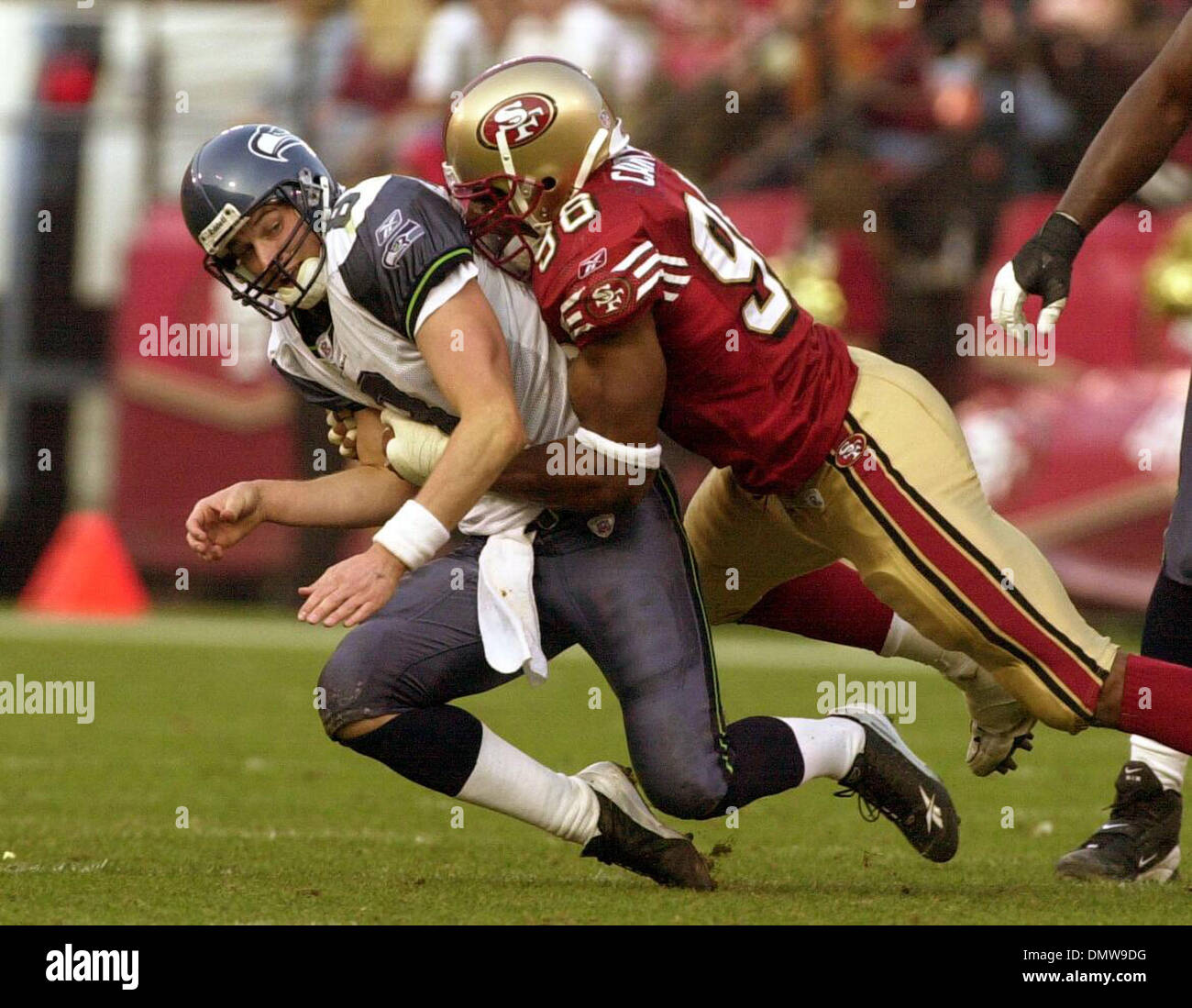 Déc 01, 2002 ; San Francisco, CA, USA, Seattle Seahawks Quarterback Matt Hasselbeck récupère la balle alors qu'il se fait frapper par 49er Andre Carter dans le 4e trimestre de leur jeu Dimanche 1er décembre à Candlestick Park de San Francisco en Californie. Les 49ers a gagné 31-24. Banque D'Images