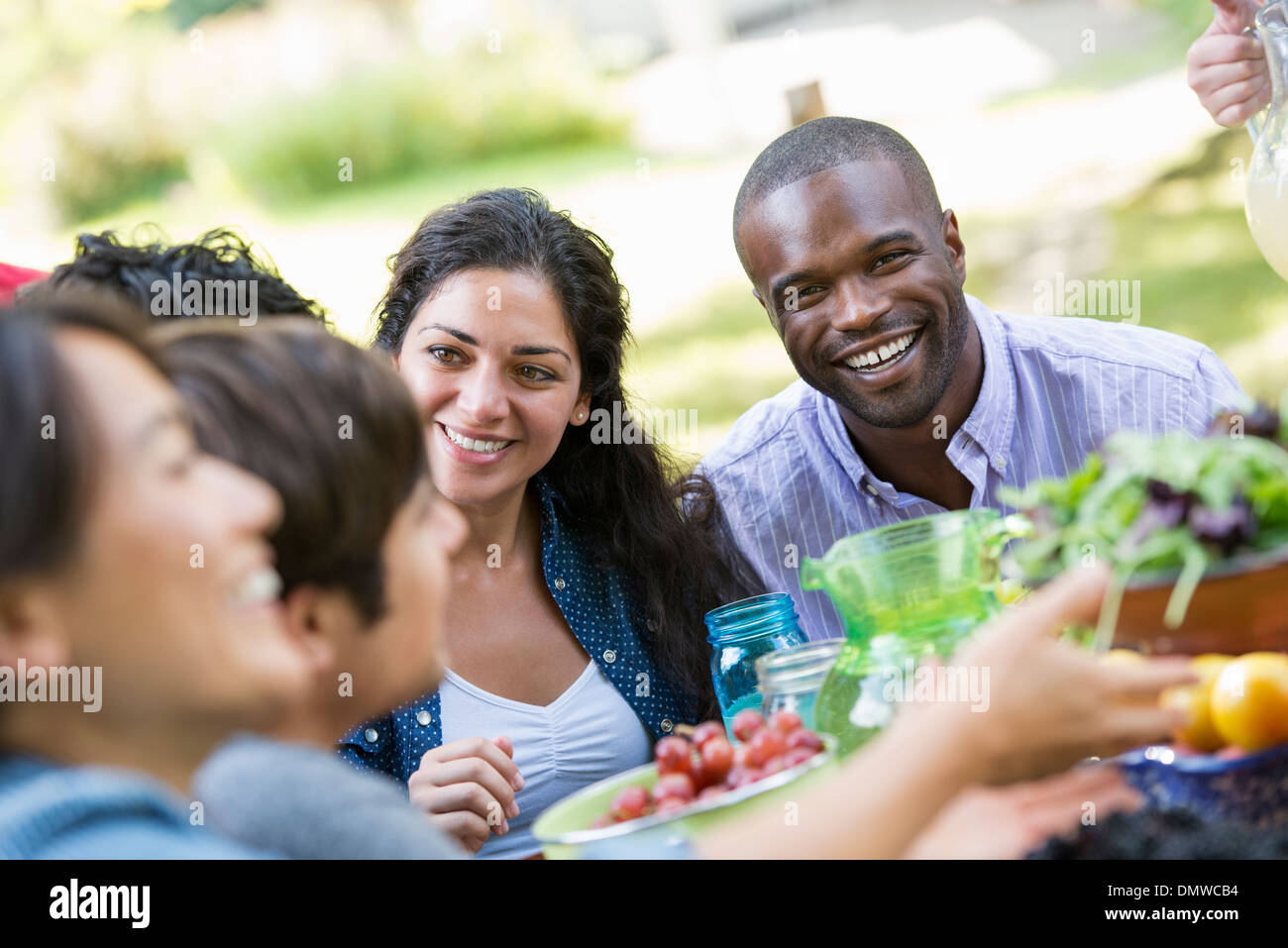 Les adultes et les enfants autour d'une table dans un jardin. Banque D'Images