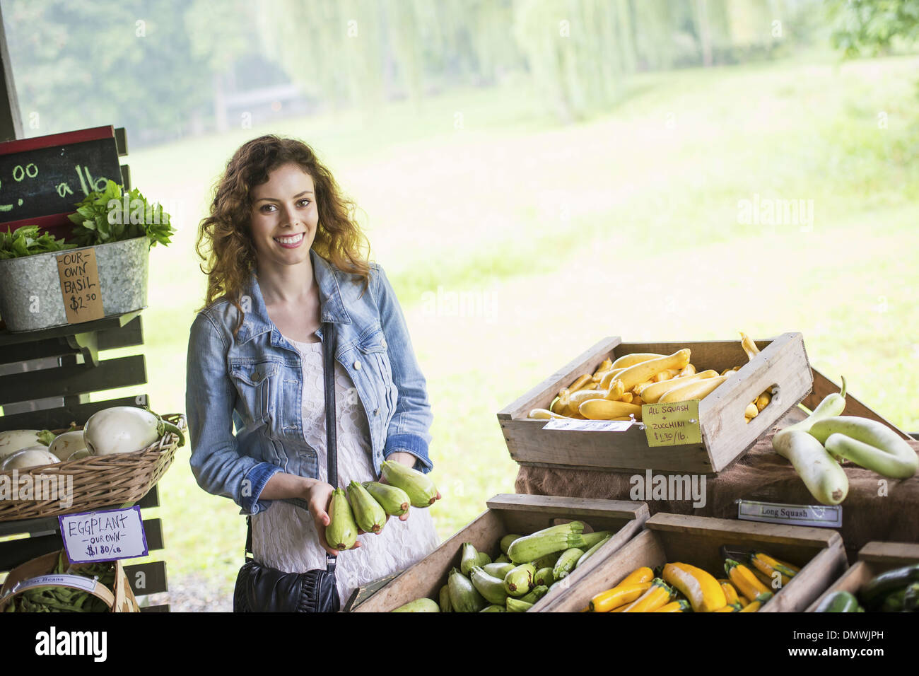 Une ferme de fruits et légumes biologiques. Une jeune femme le tri des légumes. Banque D'Images