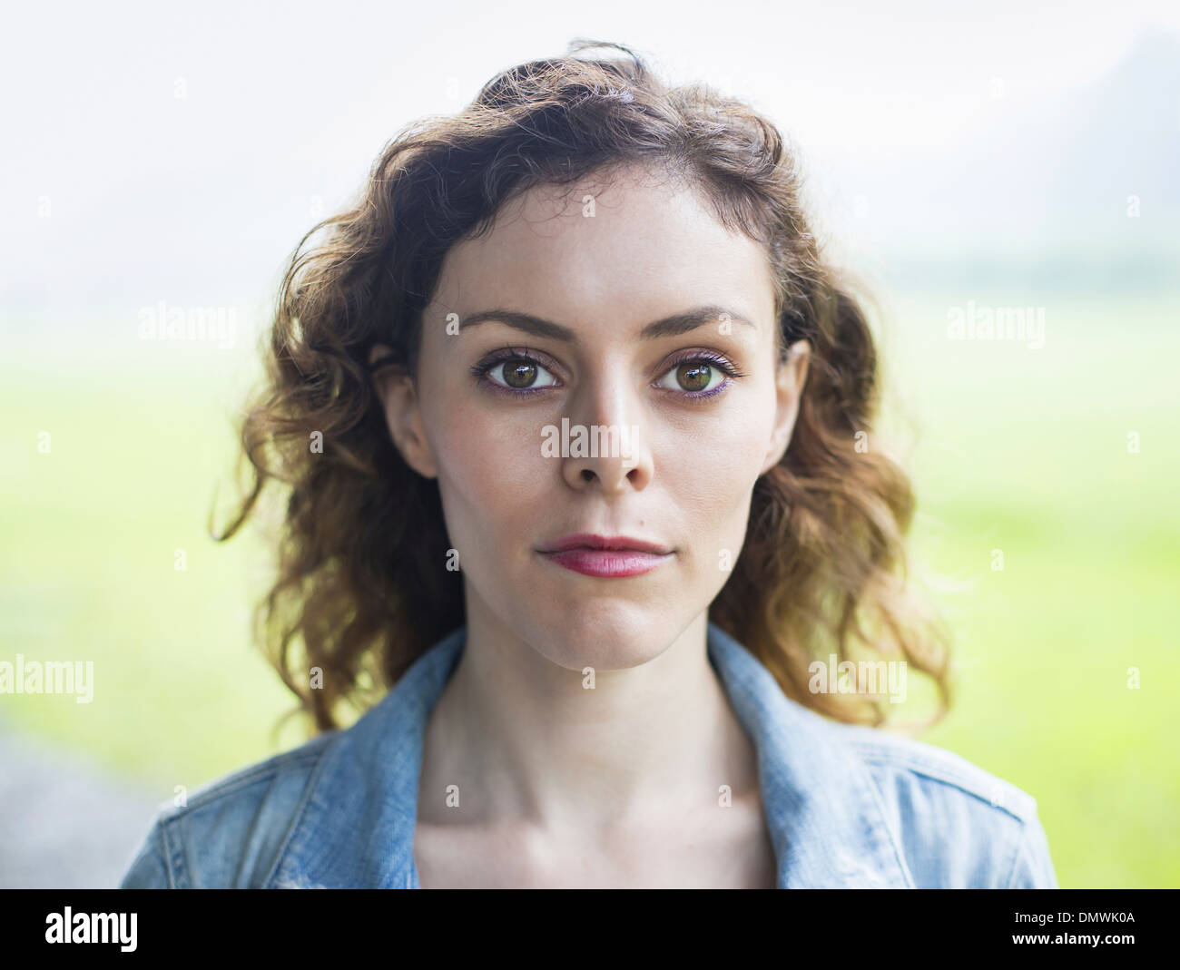 Une jeune femme dans un paysage rural avec les cheveux bouclés. Banque D'Images