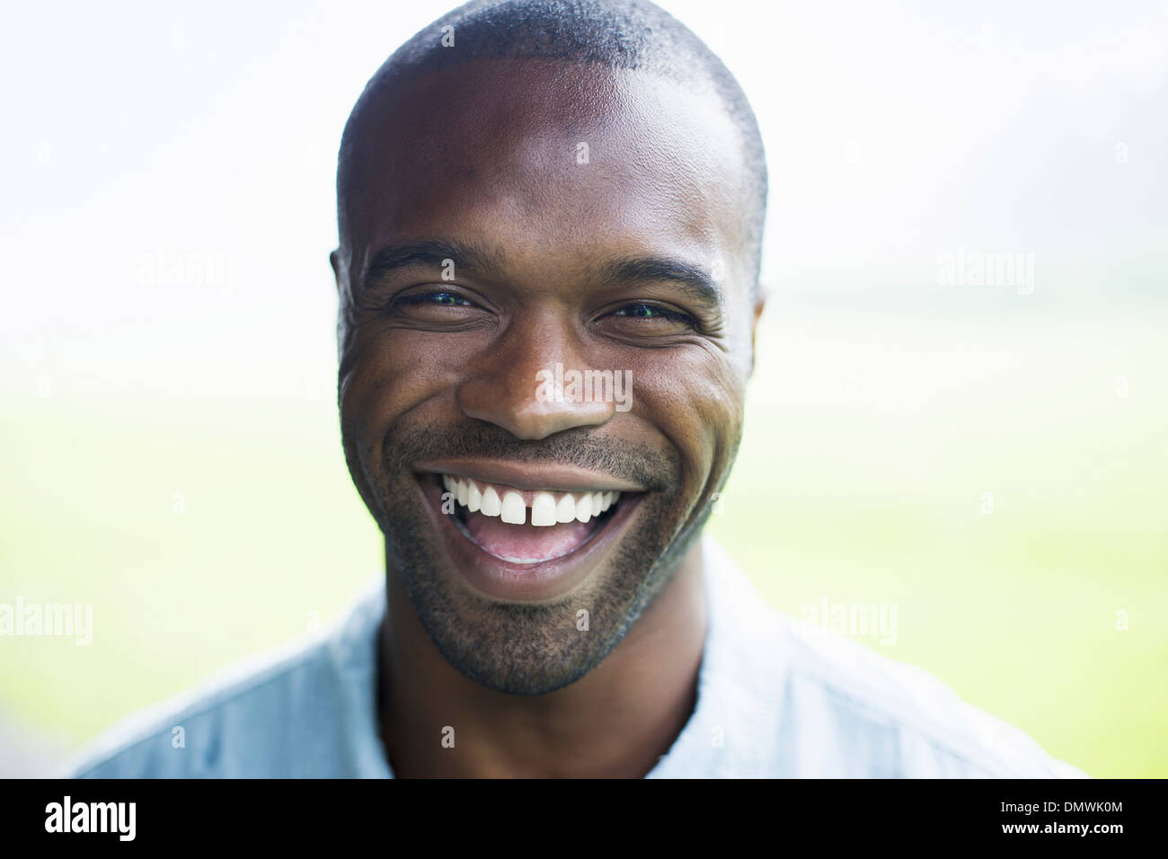 Un jeune homme en chemise bleue rire. Banque D'Images