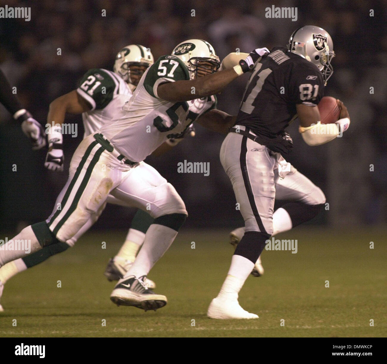 Jan 12, 2002 ; Oakland, CA, USA ; Jet Mo Lewis, 57 ans, s'empare pour Raider Tim Brown, 81, 1er trimestre jouer entre les Oakland Raiders et les New York Jets à la NFL wild-card match chez Network Associates Coliseum à Oakland, Californie, le samedi, 12 janvier 2002. Banque D'Images