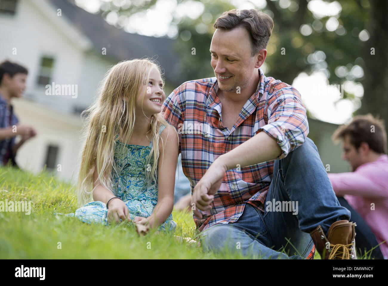 Loin d'une fille et à une fête d'été assis sur l'herbe. Banque D'Images