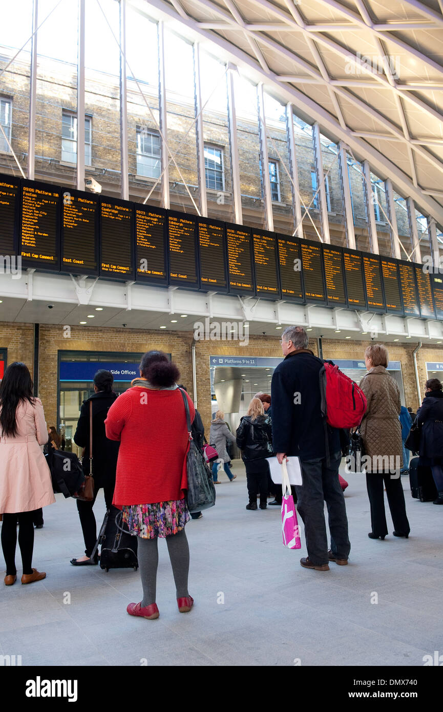 Contrôle des passagers horaires de train à la gare de Kings Cross Station, terminus de la ligne côtière est, Londres, Angleterre. Banque D'Images