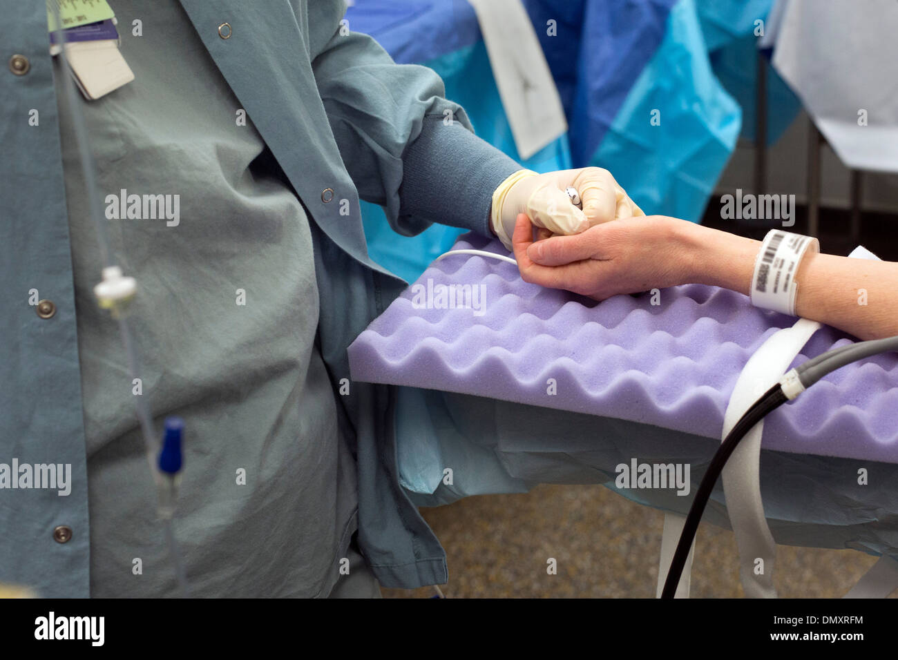 Une infirmière tient la main d'un patient en cours de préparation pour la chirurgie au Karmanos Cancer Institute. Banque D'Images