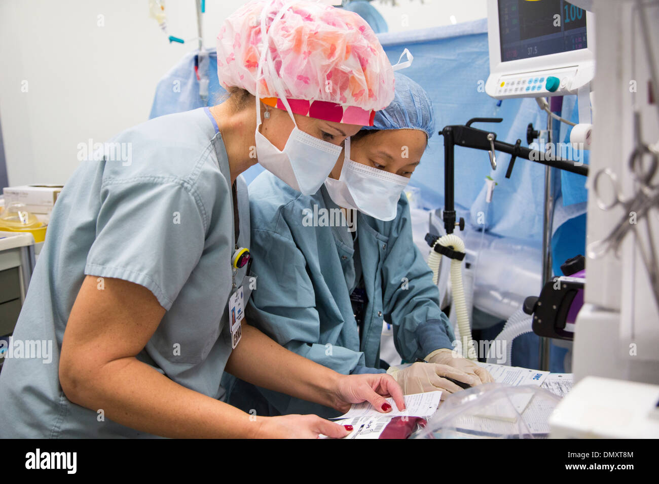 Chambre d'exploitation préparation de sang pour un patient comme chirurgiens pratiquent une hystérectomie sur une femme avec le cancer de l'endomètre. Banque D'Images
