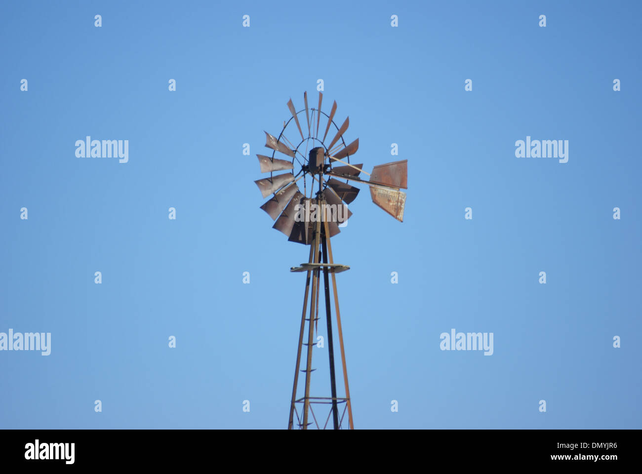 Ancien moulin à vent rouillée abandonnée contre un ciel bleu Banque D'Images