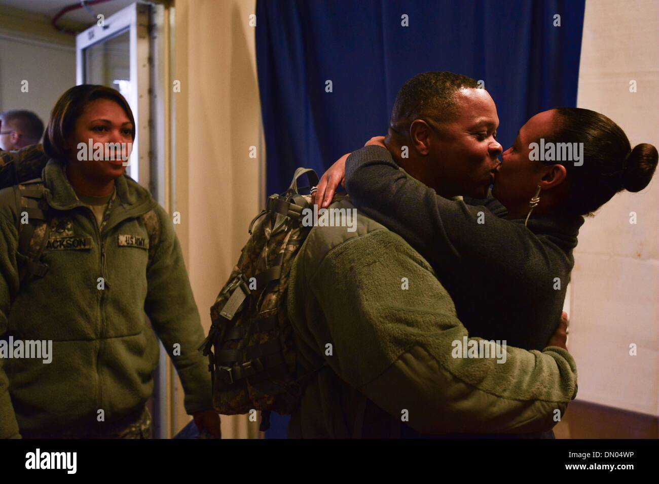 Washington, District of Columbia, US, USA. 25Th Dec 2013. Le Sgt commande. JUAN MITCHELL est accueilli avec un baiser et un câlin de sa femme Sherry Mitchell à l'Armory DC au cours d'une cérémonie de retrouvailles pour près de 50 soldats du D.C.'s Army National Guard 372e Bataillon de la Police militaire. Les soldats étaient de retour d'un déploiement de 10 mois à Guantanamo Bay, Cuba, à l'appui de l'opération Enduring Freedom. Bon nombre des militaires ont déployé au moins une fois auparavant, et neuf travailler comme agents de police bien que pas sur le devoir militaire. Credit : Miguel Juarez Lugo/ZUMAPRESS.com/Alamy Live News Banque D'Images