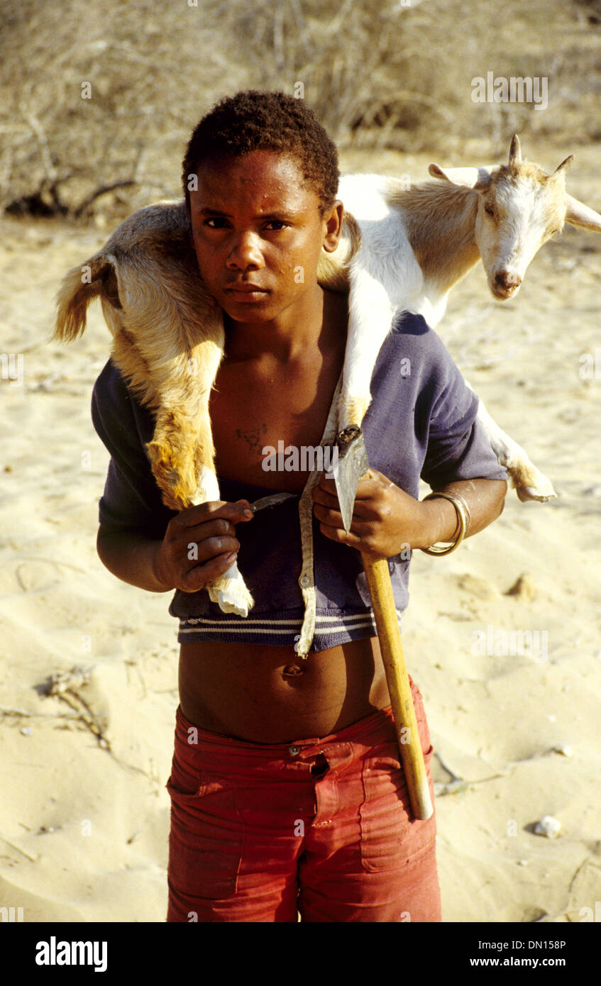 Garçon malgache de tribu Vezo transportant une chèvre sur ses épaules près de Tulear ou Toliara Madagascar Banque D'Images