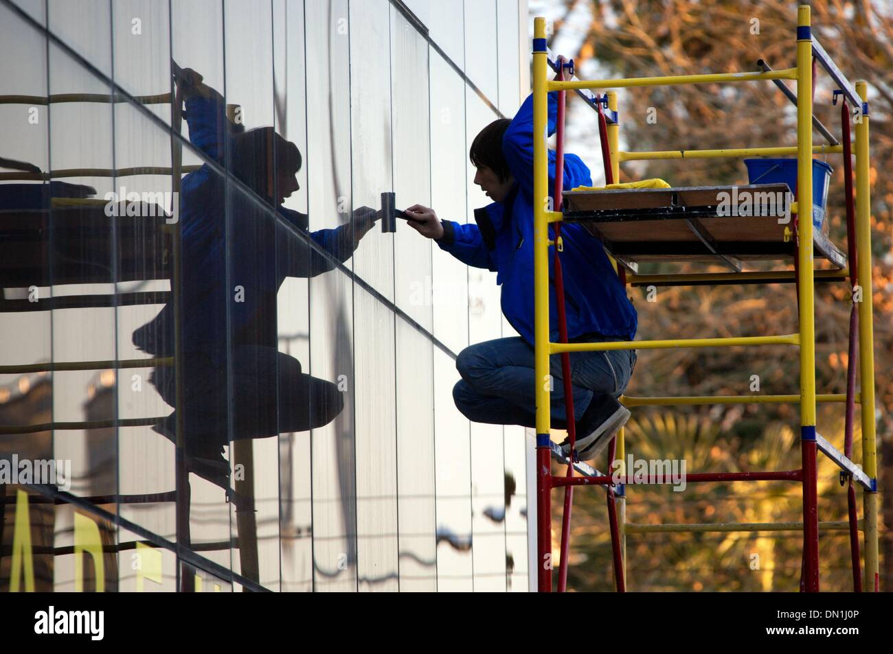 Sochi, Russie. 25Th Dec 2013. Un homme nettoie les fenêtres d'une façade d'affaires près du village olympique de Sotchi, Russie, 17 décembre 2013. Les Jeux Olympiques d'hiver auront lieu à la station de la mer Noire de Sotchi en février 2014. Photo : JENS BUETTNER/dpa/Alamy Live News Banque D'Images
