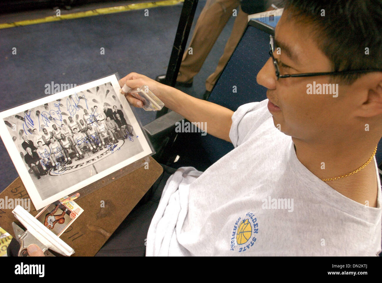 Aug 30, 2006 ; Oakland, CA, USA ; JASON WAI montre une photo de la saison 1992 qu'il veut un autographe lors de la conférence de presse pour annoncer le Don Nelson comme entraîneur-chef des guerriers. Environ 150 fans est sorti d'accueillir de nouveau, Don Nelson . Crédit obligatoire : Photo de Urquiaga/Contra Costa Times/ZUMA Press. (©) Copyright 2006 par Contra Costa Times Banque D'Images