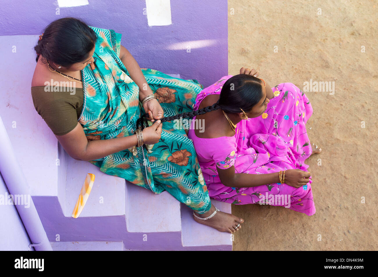 Jeune femme village ayant ses cheveux tressés par sa sœur dans la loi. L'Andhra Pradesh, Inde Banque D'Images