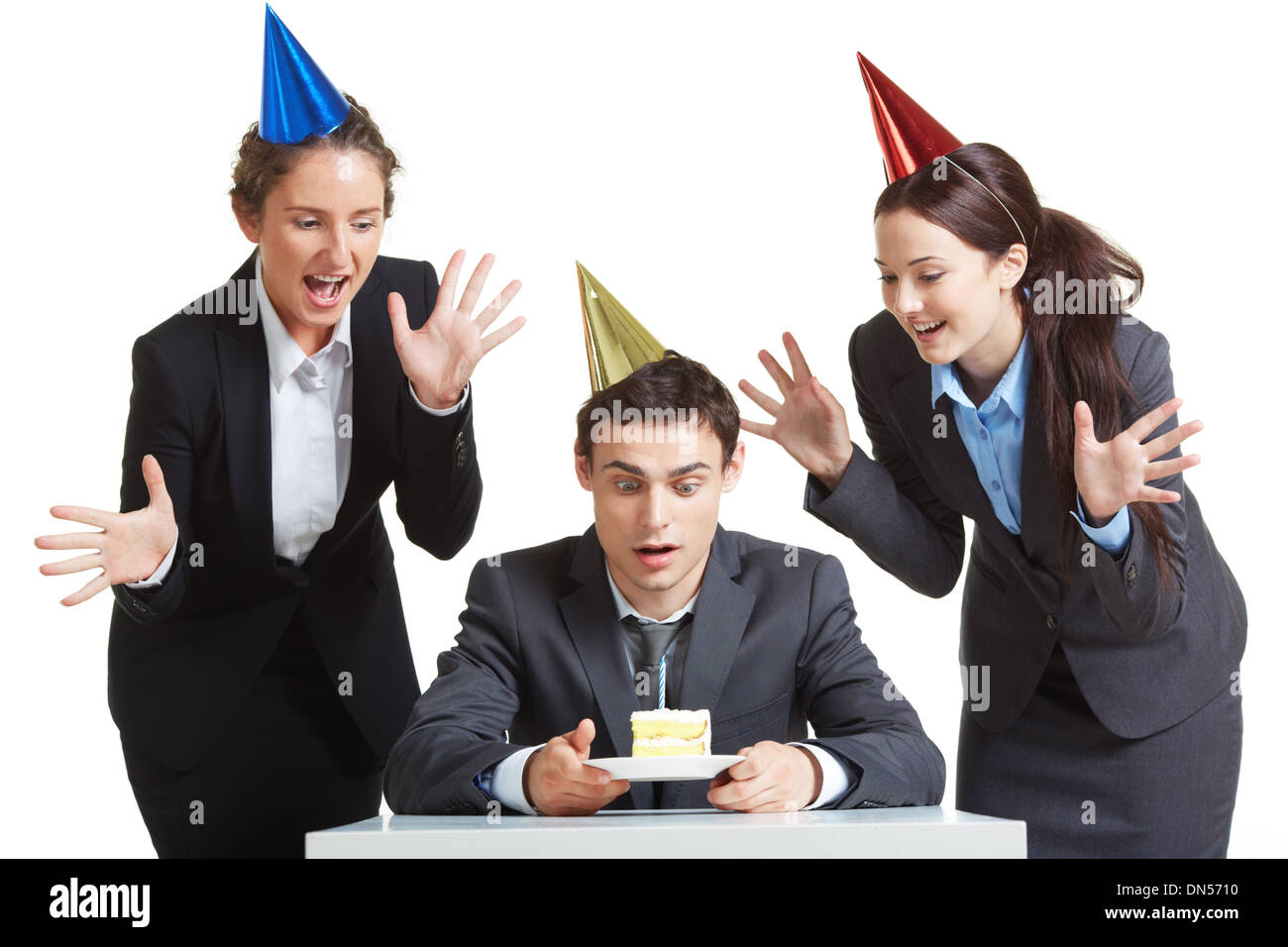 Portrait of young businessman in anniversaire cap à la recherche au morceau de gâteau avec deux femelles joyeuse près de par Banque D'Images