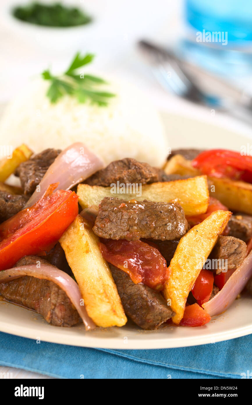 Plat appelé péruvienne Lomo Saltado faites de boeuf, tomate, oignon rouge et frites, servies avec du riz Banque D'Images