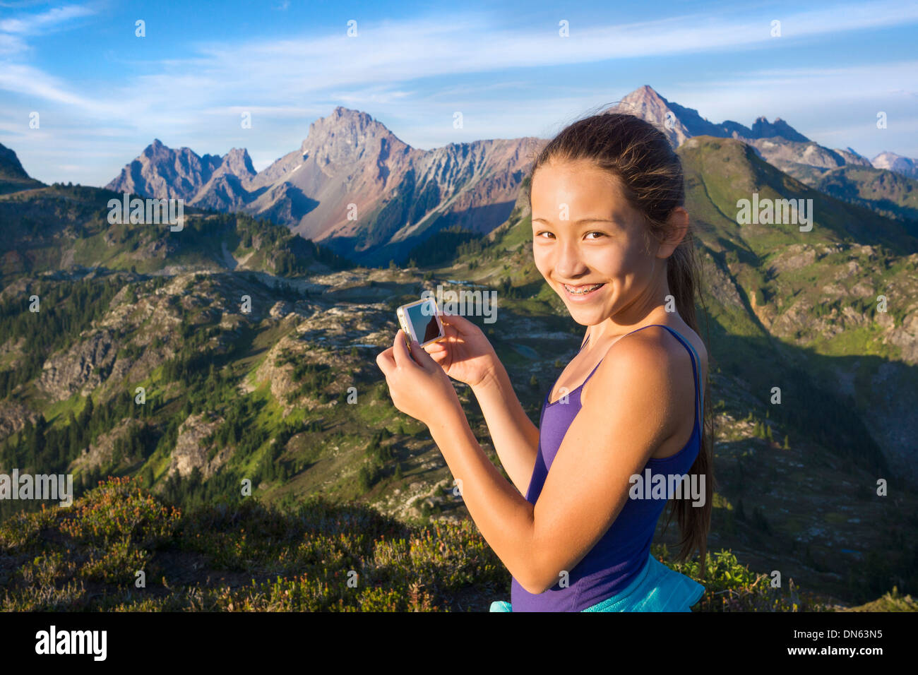 Mixed Race girl photographing mountains, North Cascades, Washington, United States Banque D'Images