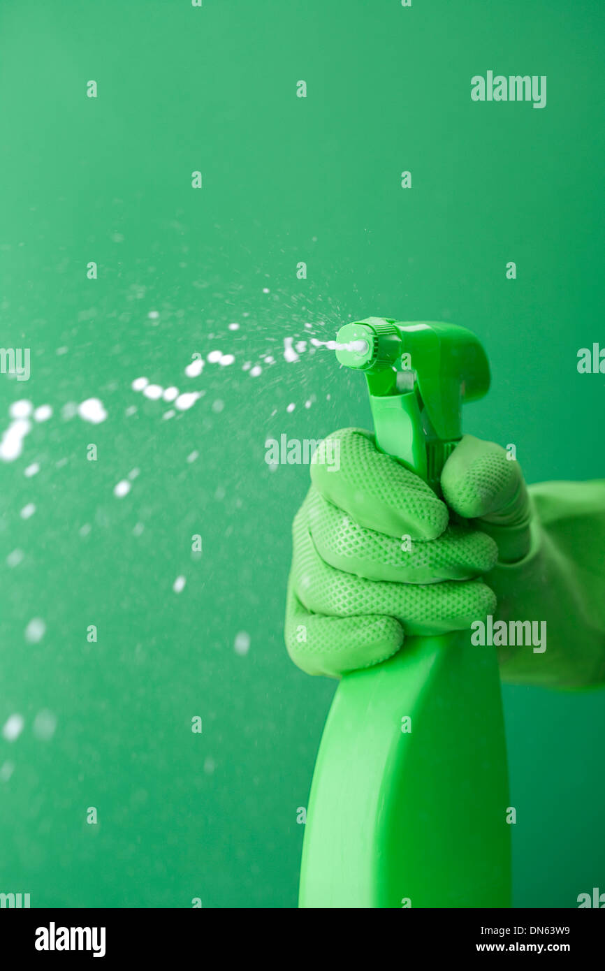 Gant en caoutchouc vert squiring spray bottle Banque D'Images