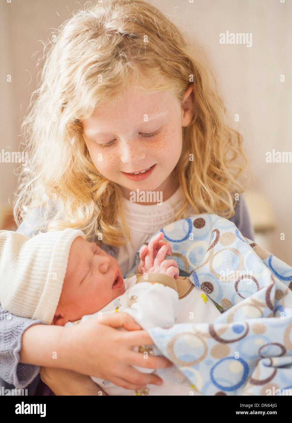 Caucasian girl holding newborn baby brother Banque D'Images