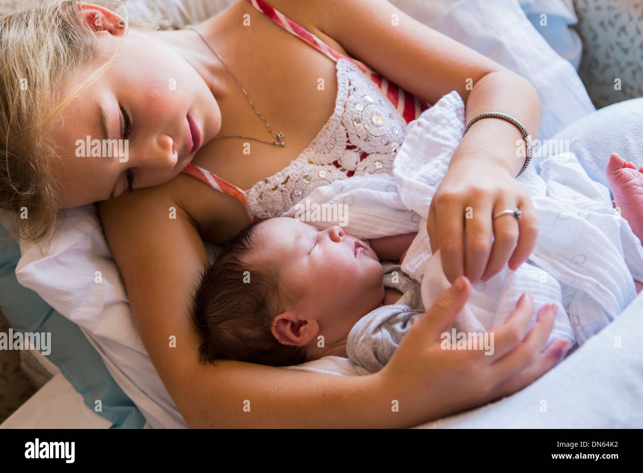 Caucasian girl holding newborn baby brother Banque D'Images